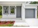 Inviting front entrance with a well-manicured yard and gray front door and garage at 2259 3Rd Ave, Deland, FL 32724