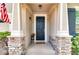 View of the front door with brick pillars, a welcome mat, and outdoor sconces at 2331 Kennington Cv, Deland, FL 32724