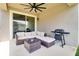 Covered outdoor patio with ceiling fan, wicker seating, and a BBQ grill at 2331 Kennington Cv, Deland, FL 32724