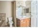 Neutral bathroom with a white vanity and toilet, tile floors, and a large framed mirror at 2503 Se 18Th Cir, Ocala, FL 34471