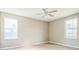 Light-filled bedroom features neutral walls, two large windows, and ceiling fan at 2503 Se 18Th Cir, Ocala, FL 34471