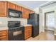 Efficient kitchen features a black range, microwave and refrigerator, plus light wood cabinets at 2503 Se 18Th Cir, Ocala, FL 34471
