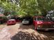 Photo of an overgrown backyard with various cars under an awning behind a few trees at 2520 Raehn St, Orlando, FL 32806