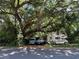 Mature trees with an RV, truck, and van parked under the shade, creating a natural carport at 2520 Raehn St, Orlando, FL 32806
