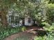 View of home's exterior with mature trees and overgrown vegetation at 2520 Raehn St, Orlando, FL 32806
