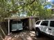 View of property garage with mature trees and some overgrown vegetation at 2520 Raehn St, Orlando, FL 32806