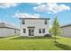 A large backyard with green grass and a young tree with a white house and dark trim at 2774 Virginia Pine Dr, Bartow, FL 33830