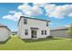 A view of the home's backyard with green grass and the back of the home with lots of windows at 2774 Virginia Pine Dr, Bartow, FL 33830