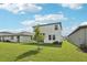 A large backyard with green grass and a young tree; the house has white siding and dark trim at 2774 Virginia Pine Dr, Bartow, FL 33830