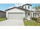 Charming two-story home with a two car garage, landscaped yard, and a light blue front door at 2774 Virginia Pine Dr, Bartow, FL 33830