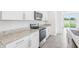 This kitchen features granite countertops, stainless appliances, white cabinets, and tile flooring at 2774 Virginia Pine Dr, Bartow, FL 33830