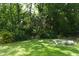 Expansive backyard featuring mature trees, lush landscaping, a manicured lawn, and inviting fire pit at 304 Little Springs Ln, Longwood, FL 32750