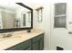 Bathroom featuring a green double vanity, dark framed mirror, and hooks for storage at 304 Little Springs Ln, Longwood, FL 32750