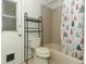 Bathroom showcasing a toilet, bathtub, patterned shower curtain, and shelving unit at 304 Little Springs Ln, Longwood, FL 32750
