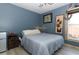 Bedroom with blue walls, wooden furnishings, and natural light from the window at 304 Little Springs Ln, Longwood, FL 32750