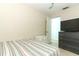 Cozy bedroom featuring a striped bedspread, white nightstand, and a dark wooden dresser with a TV at 304 Little Springs Ln, Longwood, FL 32750