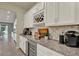 This bar area has white cabinetry, a beverage cooler, granite countertops, and a decorative tile backsplash at 3259 Buoy Cir, Winter Garden, FL 34787