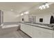 Bright bathroom featuring a tiled floor, a soaking tub, walk-in shower, granite countertops, and dual sinks at 3259 Buoy Cir, Winter Garden, FL 34787