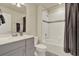 Bathroom featuring light grey cabinets, quartz countertops, and a bathtub with tiled shower and a dark curtain at 3259 Buoy Cir, Winter Garden, FL 34787