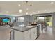 Open kitchen with stainless steel appliances, granite countertops, an island with seating, and open to living area at 3259 Buoy Cir, Winter Garden, FL 34787