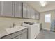 Well-equipped laundry room with gray cabinets, countertop space, and modern washer and dryer for efficient laundry tasks at 3259 Buoy Cir, Winter Garden, FL 34787