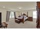 Comfortable main bedroom featuring a four-poster bed, soft carpeting, and plenty of natural light from the windows at 3259 Buoy Cir, Winter Garden, FL 34787