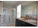 Bathroom featuring a double sink vanity with shower behind glass doors and large mirror at 3416 Seneca Club Loop # 56, Orlando, FL 32808