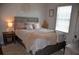 Cozy bedroom featuring a comfortable bed with plush pillows, side tables, and a large window at 3416 Seneca Club Loop # 56, Orlando, FL 32808