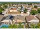 Aerial view of the home with a screened-in pool in a residential neighborhood at 386 Riggs Cir, Davenport, FL 33897