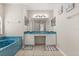 Bright bathroom featuring a soaking tub and a double sink vanity with a large mirror at 386 Riggs Cir, Davenport, FL 33897
