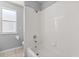 Full bathroom with white tile and a shower-tub combination, plus window at 386 Riggs Cir, Davenport, FL 33897