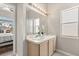 Well-lit bathroom featuring double sinks, natural light and an open view to the primary bedroom at 386 Riggs Cir, Davenport, FL 33897