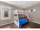 Bedroom with white bunk bed, dark floors and a window at 386 Riggs Cir, Davenport, FL 33897