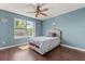 Comfortable bedroom with a ceiling fan, a window with backyard views, and dark wood floors at 386 Riggs Cir, Davenport, FL 33897
