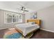 Comfortable bedroom with natural light, ceiling fan, and a modern area rug on hardwood floors at 386 Riggs Cir, Davenport, FL 33897