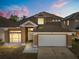 Charming two-story home featuring a well-manicured lawn and attached two-car garage at 386 Riggs Cir, Davenport, FL 33897