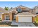 Charming two-story home featuring a well-manicured lawn and attached two-car garage at 386 Riggs Cir, Davenport, FL 33897