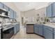 Bright kitchen showcasing stainless steel appliances, light blue cabinets, and adjacent dining area at 386 Riggs Cir, Davenport, FL 33897