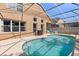 Relaxing screened-in pool features cool, crystal blue water and ample seating at 386 Riggs Cir, Davenport, FL 33897