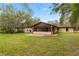 Backyard of home showing large grassy area, concrete patio, and screened-in lanai at 4495 Bedford Rd, Sanford, FL 32773