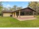 Home exterior featuring a screened patio, a green lawn, and a concrete patio area at 4495 Bedford Rd, Sanford, FL 32773