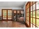 Open living space showcasing wood floors, a built-in bookshelf, and French doors leading outside at 4495 Bedford Rd, Sanford, FL 32773