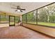 A screened patio with a ceiling fan and view of the spacious tree-filled backyard at 4495 Bedford Rd, Sanford, FL 32773