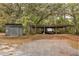 Outbuilding with shed and covered RV or boat parking nestled among mature oak trees and foliage at 4495 Bedford Rd, Sanford, FL 32773