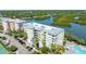 Stunning aerial view of a waterfront condo building with a pool and lush landscaping at 5 Riverwalk Dr # 604, New Smyrna Beach, FL 32169