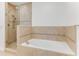 Luxurious bathroom features a shower and a soaking tub with stone tile surround at 5 Riverwalk Dr # 604, New Smyrna Beach, FL 32169