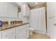 Well-lit bathroom with granite countertop, white cabinets, and a shower featuring a white curtain at 5 Riverwalk Dr # 604, New Smyrna Beach, FL 32169