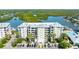 Exterior view of a condo building with lush green landscape and parking in front at 5 Riverwalk Dr # 604, New Smyrna Beach, FL 32169