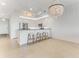 Open kitchen with a breakfast bar, pendant lighting, white cabinets, and stainless steel appliances at 5 Riverwalk Dr # 604, New Smyrna Beach, FL 32169