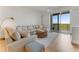 Relax in this comfortable living room with plush sectional, wood accents, and scenic balcony access at 5 Riverwalk Dr # 604, New Smyrna Beach, FL 32169